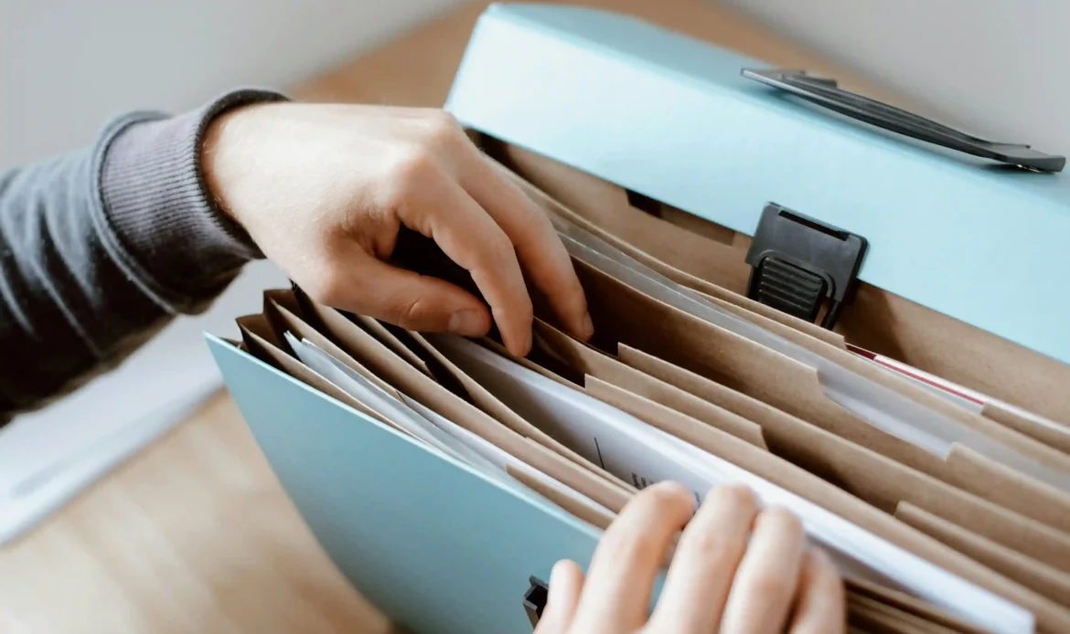 A Person Looks Through an Accordion File Folder Signifying an Organized Municipality Website.