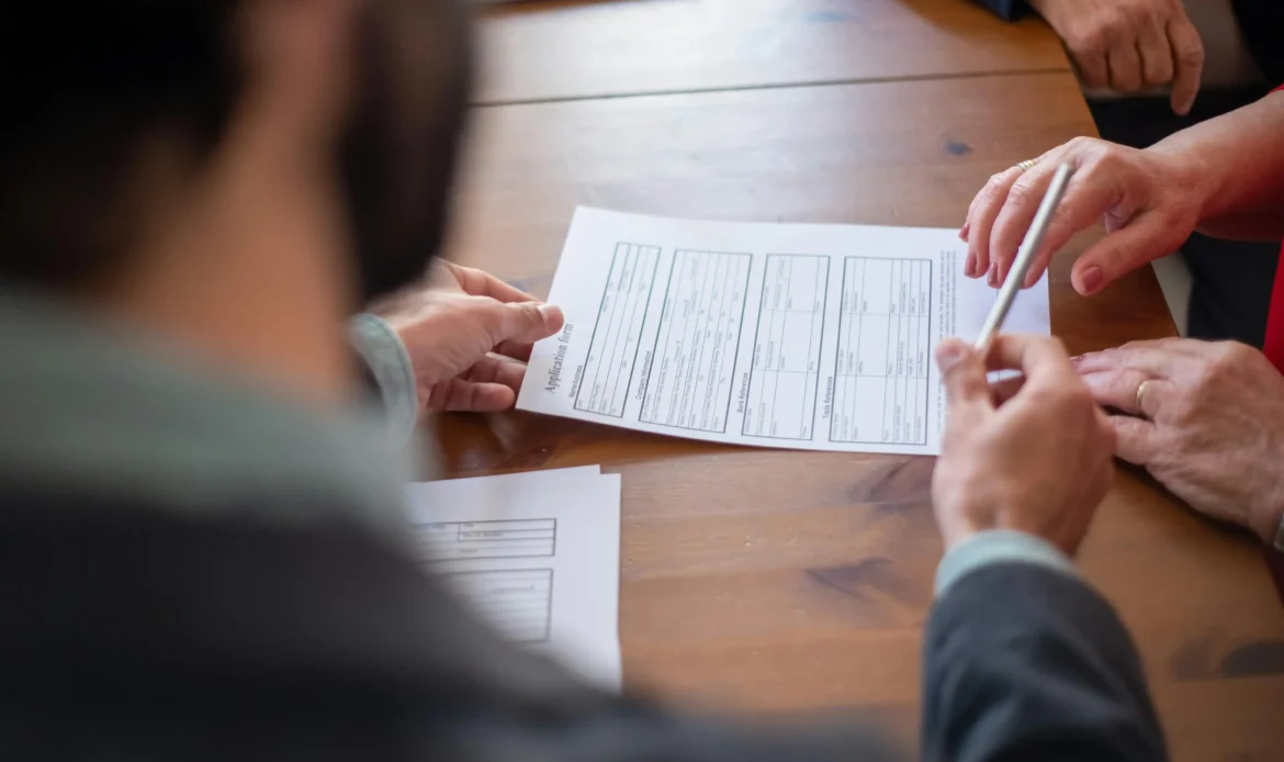 Three People Review a Document Signifying the Specific Exceptions to the Title II ADA Ruling.